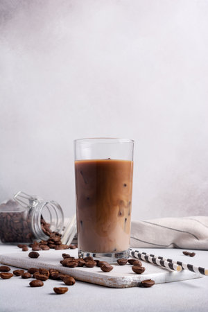 Homemade ice latte. Black coffee with ice and milk or cream in glass for tasty and refreshing break on grey backgroundの写真素材