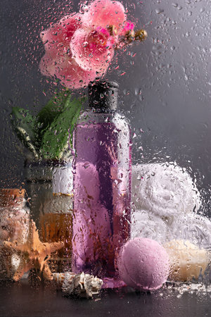 Pink shower gel, bath bomb and sea salt with orchid flower and white towels for spa and relax on glass shower cabin, bathの写真素材
