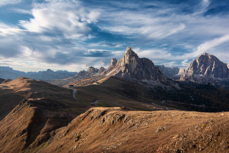 Scenic landscape of beautiful autumn Dolomites Alps on blue cloudy sky backgroundの写真素材