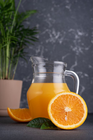 Glass jug of fresh orange juice with ripe orange fruitsの写真素材