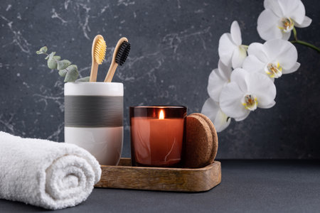 Scented candle and bamboo toothbrush in dark bathroom interiorの写真素材