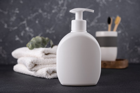 White empty shampoo or lotion bottle for mock-up in modern dark bathroom interiorの写真素材