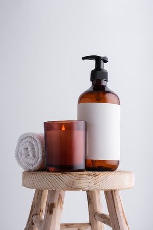 Eco-friendly brown dispenser with shower gel, liquid soap or shampoo on a wooden stool in the bathroomの写真素材