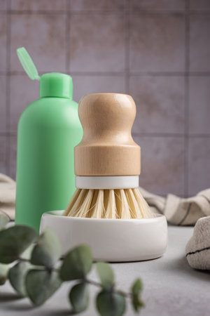 Eco friendly kitchen concept, sustainable lifestyle. Set for cleaning, as dish wash brush, green bottle and towels with eucalyptusの写真素材