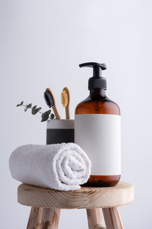 Eco-friendly brown dispenser with shower gel, liquid soap or shampoo on a wooden stool in the bathroomの写真素材