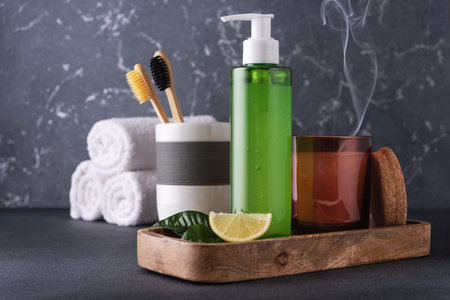 Natural cosmetic products for the bathroom. Green shower gel or shampoo, bamboo toothbrushes and scented candleの写真素材
