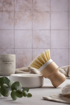 Eco friendly kitchen concept, sustainable lifestyle. Set for cleaning and cozy home, as dish wash brush, towel with eucalyptus and candleの写真素材