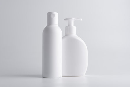 White cosmetic shampoo and lotion dispenser bottle mock-up on grey backgroundの写真素材