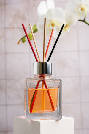Transparent glass bottle of reed diffuser, air freshener for aromatherapy, relax, cozy atmosphere, spa on tile bathroom backgroundの写真素材