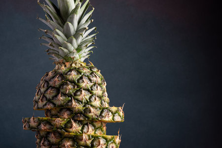 Ripe sliced ââpineapple on a dark background close-upの写真素材