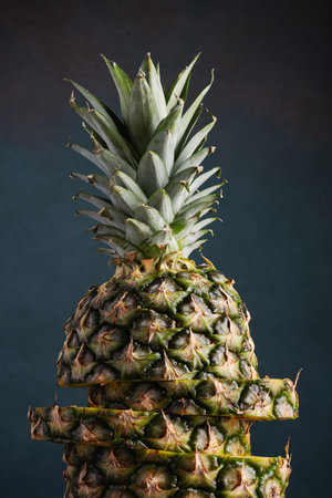 Ripe sliced ââpineapple on a dark background close-upの写真素材