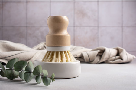 Eco friendly kitchen concept, sustainable lifestyle. Dish wash brush and towel with green eucalyptusの写真素材