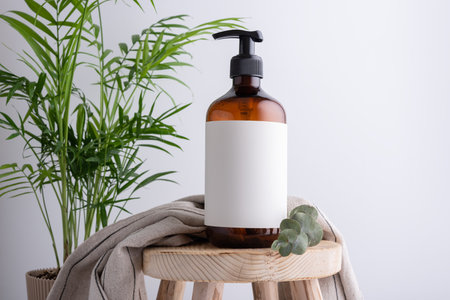 Eco-friendly brown dispenser with shower gel, liquid soap or shampoo on a wooden stool in the bathroomの写真素材