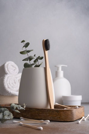 Natural eco friendly bamboo toothbrush and white bathroom towelsの写真素材