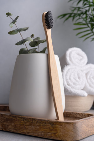 Natural eco friendly bamboo toothbrush and white bathroom towelsの写真素材