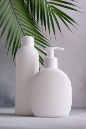 White blank packaging cosmetic plastic bottle with palm leaves. Bathroom and grooming product.の写真素材