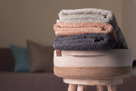 Cotton rope basket with a folded pastel colors terry towels in a room interiorの写真素材