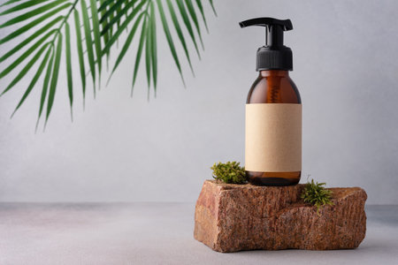Brown glass bottle standing on moss stone for cosmetic product mock up. Natural organic cosmetic conceptの写真素材