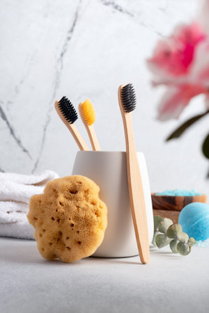 Eco-friendly bathroom accessories: bamboo toothbrushes and natural sea sponge. Zero waste spa and...