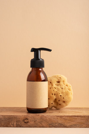 Brown glass bottle with a sea sponge on a yellow background. Concept for a natural bath and skincare product.の写真素材