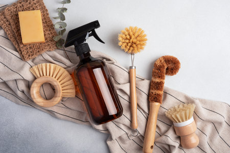Eco-friendly cleaning set with amber soap bottle and wooden dish brushes. Sustainable homecare concept.の写真素材