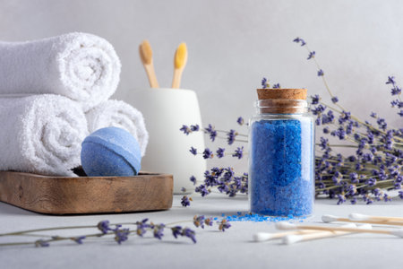 Homemade lavender bath salt in glass jar, lavender flowers and bathroom accessories. Wellness concept and spa products.の写真素材