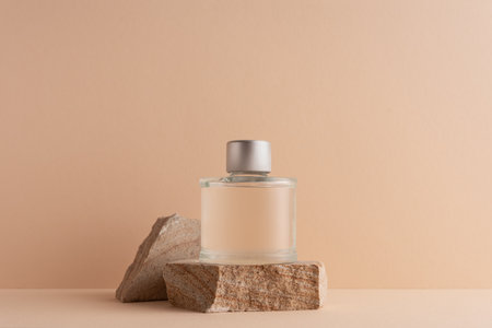 Mockup stone podium with glass perfume bottle on beige background