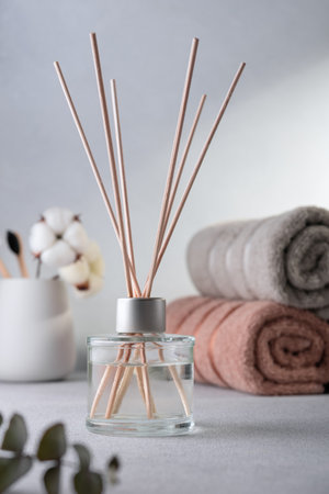Reed aroma diffusor in domestic interior. Cozy home bathroom atmosphere. Concept of relaxation with...