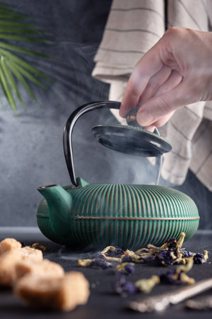 Asian tea made in a cast iron teapot with brown sugarの写真素材