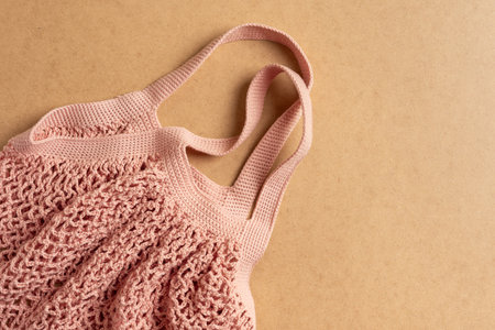 Homemade crochet string bag on beige background. Zero waste concept. Eco-friendly bag for grocery.
