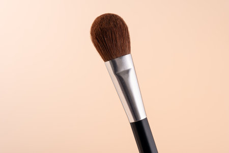 Makeup brush for applying face powder isolated on pastel beige backgroundの写真素材