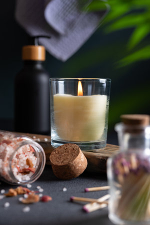 Concept of spa treatment at home. Aroma candle, bath salt and other product for body care. Dark bathroom interior with atmosphere of relax, serenity and pleasure.の写真素材