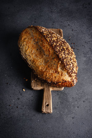 Organic homemade whole grain bread on wooden cutting board. Delicious brown bread made from whole...