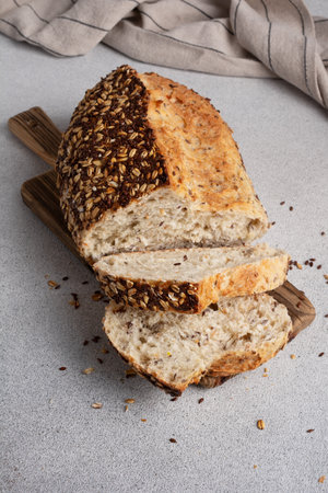Organic homemade whole grain bread on wooden cutting board. Delicious brown bread made from whole grain flour for a healthy dietの写真素材
