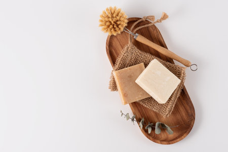 Organic soap bars, washcloth and bamboo brush on wooden tray, top view. Cleaning concept.の写真素材