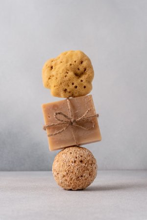 Natural handmade soap bar on sphere stone podium with natural sea sponge. Organic and sustainable bathroom lifestyle concept.の写真素材