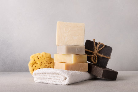 Stack of handcrafted soap bars, white terry towel and natural sea sponge. Natural, organic cleaning and bath concept.の写真素材