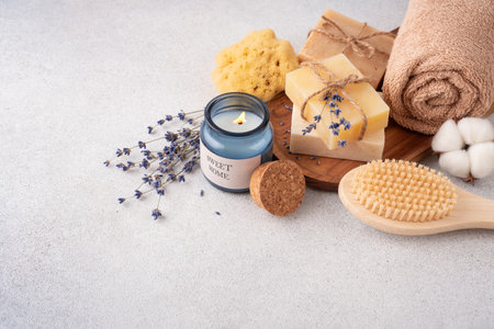 Bathroom items with crafted bars of soap, towel, aroma candle and wooden back brush. Spa and selfcare organic product for eco friendly and sustainable lifestyle.の写真素材