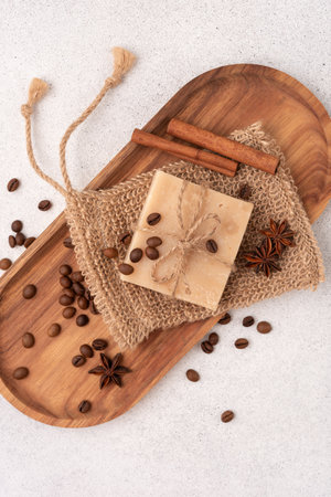 Crafted bar of soap with roasted coffee beans, cinnamon and anise on wooden tray. Spa and selfcare organic product for eco friendly and sustainable lifestyle.の写真素材
