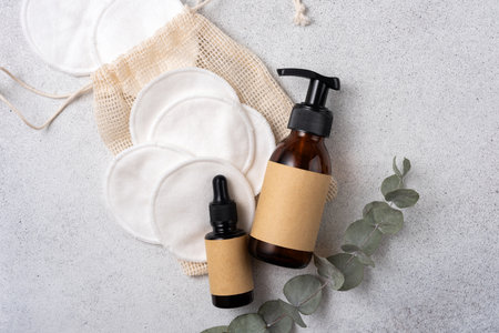 Reusable cotton pads for makeup removal and brown glass cosmetic bottles. Sustainable, eco friendly, zero waste personal hygiene concept for eco-friendly skincare routines with reusable and natural materials.の写真素材