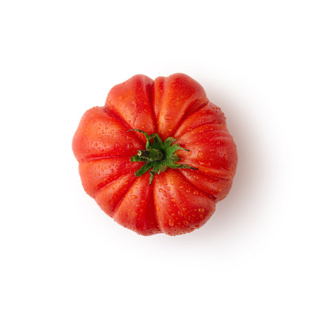 A plump, vibrant red heirloom tomato, glistening with fresh water droplets, juicy and rich flavor isolated on white. Ð¡oncept of healthy, organic foodの写真素材