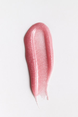 Pink cosmetic or skincare product smear with glossy texture on white background. Ideal for beauty, cosmetics, or wellness concepts.の写真素材