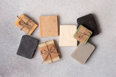 A collection of assorted handmade soap bars on grey concrete background. Sustainable and organic bodycare concept.の写真素材