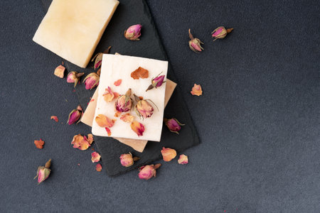 Handmade natural soap bars with dried rose petals on a dark background. Perfect for wellness, spa, organic skincare, aromatherapy, and romantic beauty concepts.の写真素材
