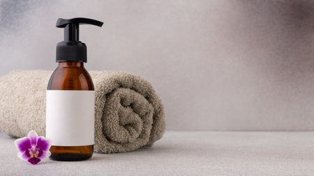 Self care set with bottle of lotion and a cotton towel. Minimal spa composition. Wellness and self care and body care concept.の写真素材