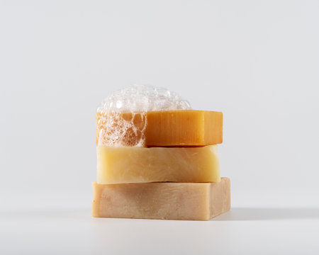 Crafted soap bars with foamy bubbles on a white background. Perfect for natural skincare, hygiene, and eco-friendly product themes.の写真素材