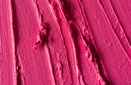 Closeup of pink glossy lipstick texture with smooth strokes and rich pigmentation. Vibrant, artistic, and luxurious cosmetic smear background for beauty, fashion, and makeup concepts.の写真素材