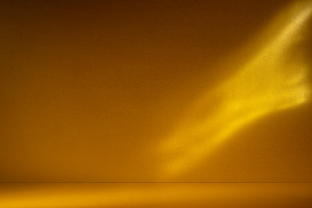 Golden background with soft sunlight and caustic light patterns. Abstract, glowing texture perfect for luxury, design, and festive themes.の写真素材