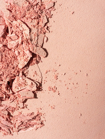 Close-up of broken pink powder blush. Crushed cosmetic texture for beauty, fashion, and makeup design. Minimalistic and elegant composition with soft tones.の写真素材