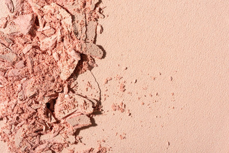 Close-up of broken pink powder blush. Crushed cosmetic texture for beauty, fashion, and makeup design. Minimalistic and elegant composition with soft tones.の写真素材